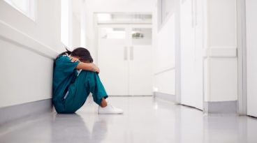 nurse sitting with head in hands